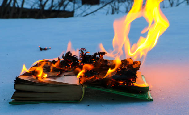 istock burning book in  snow. pages with the text in  open book burn with  bright flame. 1135948438