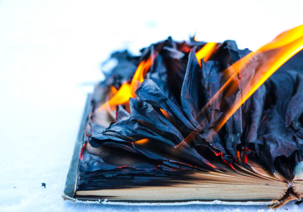 istock burning book in  snow. pages with the text in  open book burn with  bright flame. 1135948439