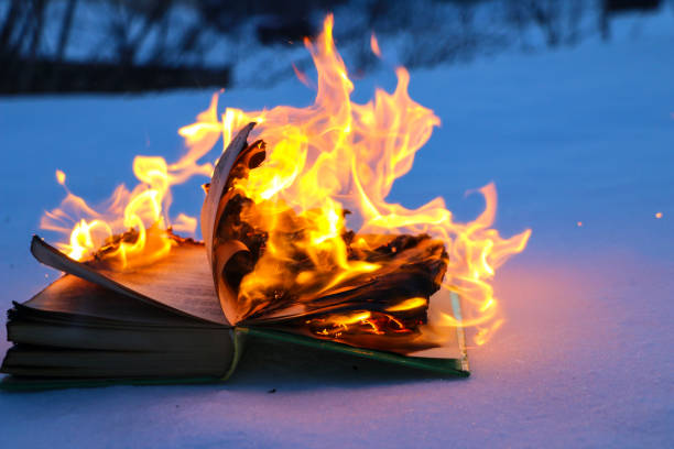istock burning book in  snow. pages with the text in  open book burn with  bright flame. 1135948442