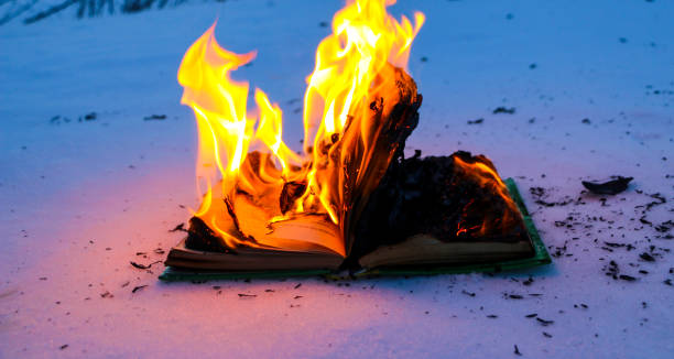 istock burning book in  snow. pages with the text in  open book burn with  bright flame. 1135948446