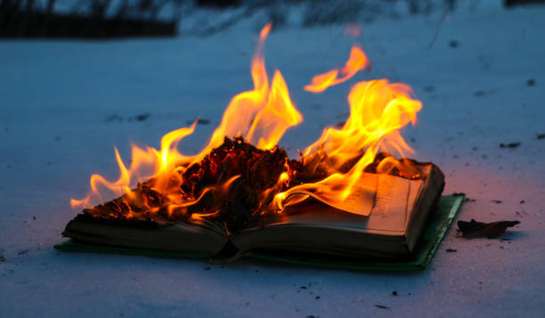 burning book in  snow. pages with the text in  open book burn with  bright flame.