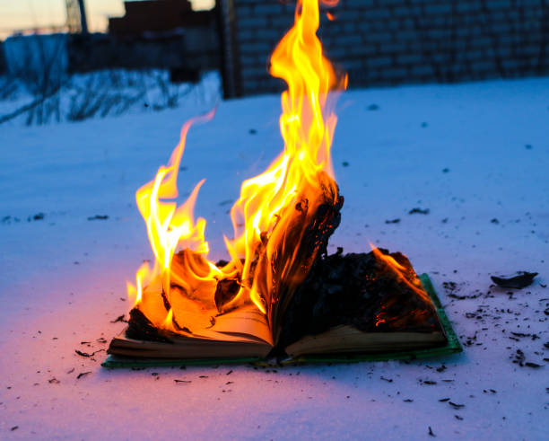 istock burning book in  snow. pages with the text in  open book burn with  bright flame. 1135948448