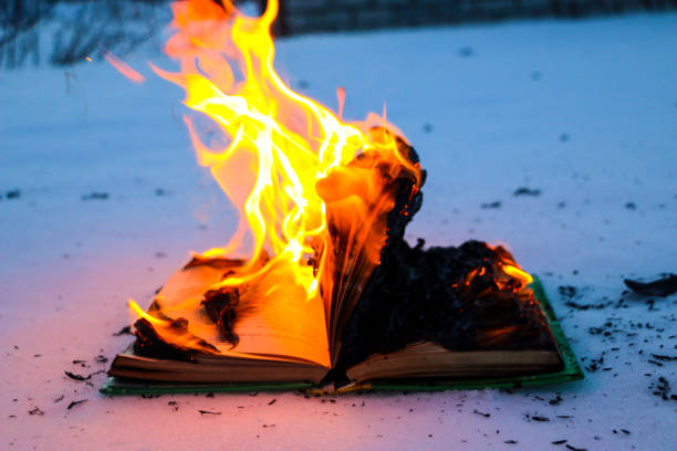 istock burning book in  snow. pages with the text in  open book burn with  bright flame. 1135948452