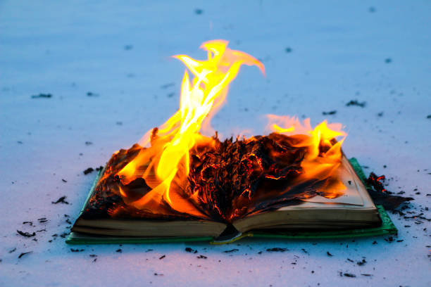 istock burning book in  snow. pages with the text in  open book burn with  bright flame. 1135948454
