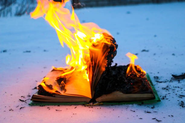 istock burning book in  snow. pages with the text in  open book burn with  bright flame. 1135948455