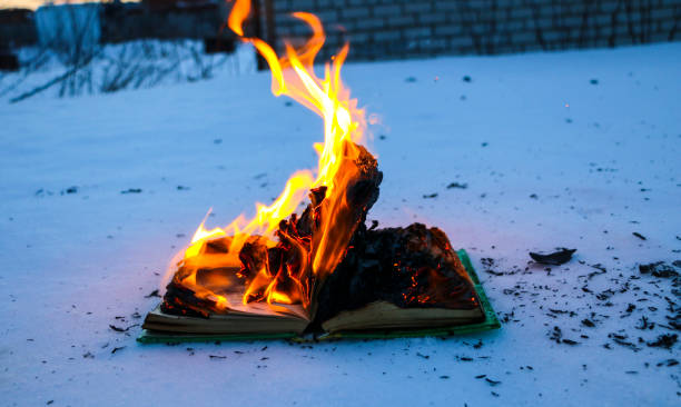 istock burning book in  snow. pages with the text in  open book burn with  bright flame. 1135948458