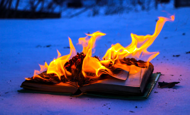 istock burning book in  snow. pages with the text in  open book burn with  bright flame. 1135948460