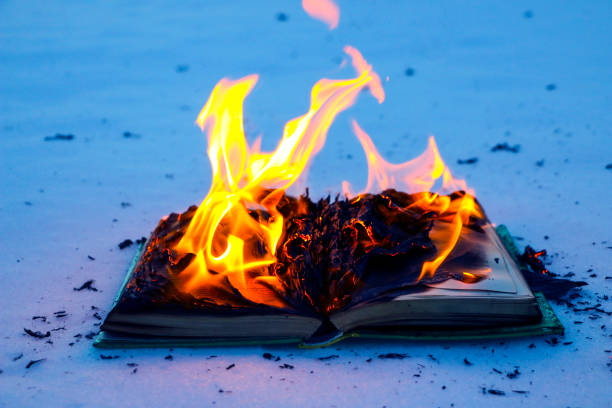 istock burning book in  snow. pages with the text in  open book burn with  bright flame. 1135948461