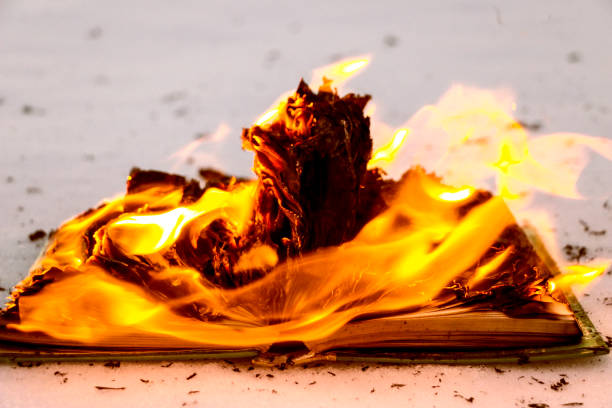 burning book in  snow. pages with the text in  open book burn with  bright flame. burning book in the snow. pages with the text in the open book burn with a bright flame. book burning stock pictures, royalty-free photos & images