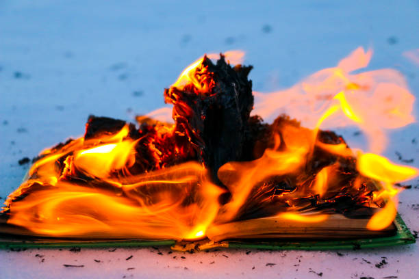 istock burning book in  snow. pages with the text in  open book burn with  bright flame. 1135948463