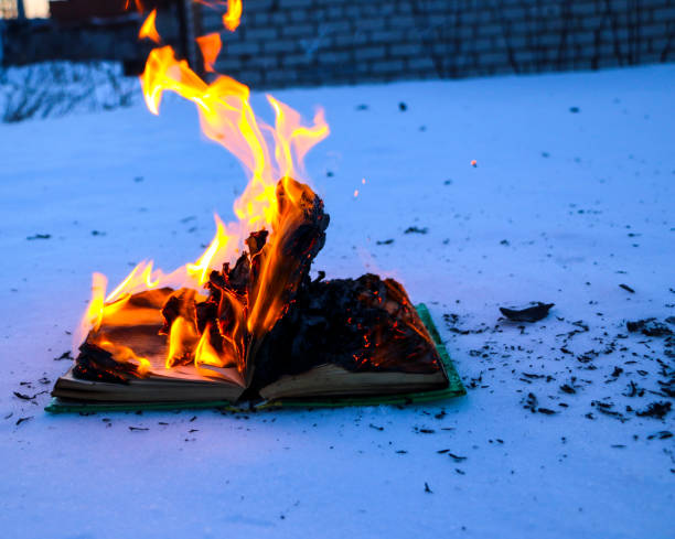 istock burning book in  snow. pages with the text in  open book burn with  bright flame. 1135948466