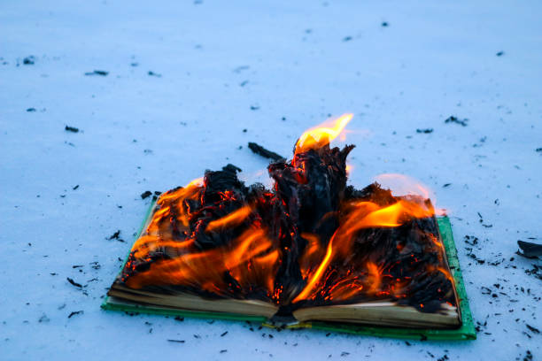 istock burning book in  snow. pages with the text in  open book burn with  bright flame. 1135948471