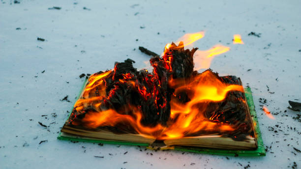 istock burning book in  snow. pages with the text in  open book burn with  bright flame. 1135948472