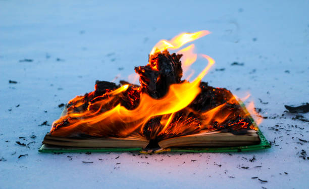 istock burning book in  snow. pages with the text in  open book burn with  bright flame. 1135948473