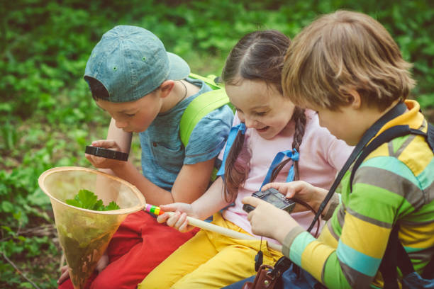 虫眼鏡の子供たちが自然の神秘を発見 - children only adventure exploration education ストックフォトと画像