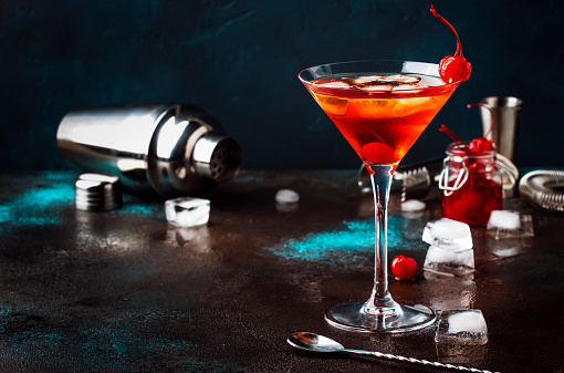 Clásico cóctel alcohólico Manhattan con Bourbon, vermut rojo, amargo, hielo y cereza cóctel en vidrio, Fondo de barra gris bar, lugar para el texto, enfoque selectivo photo