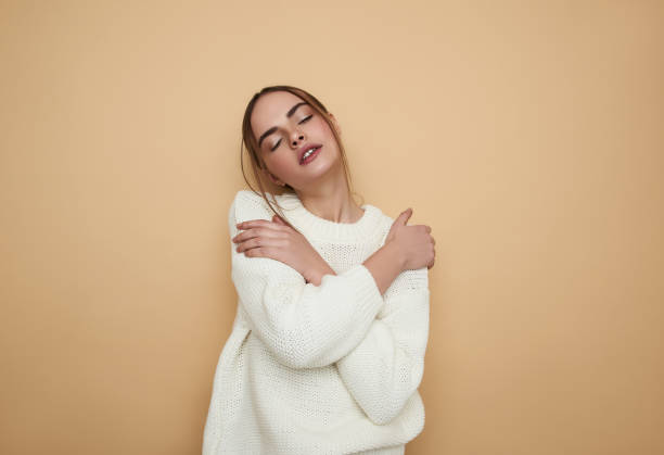 istock Relaxed girl closing eyes and hugging her shoulders 1135949332