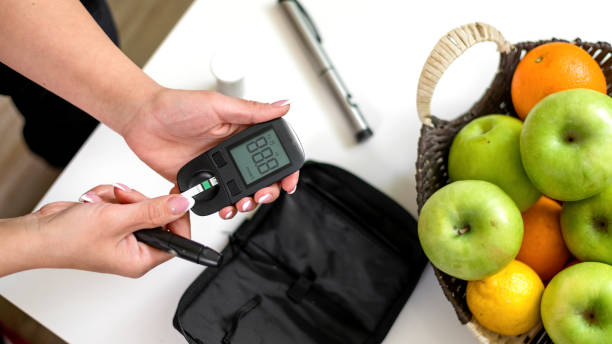 jeune femme prenant le test de glycémie - insulin food blood sugar test diabetes photos et images de collection