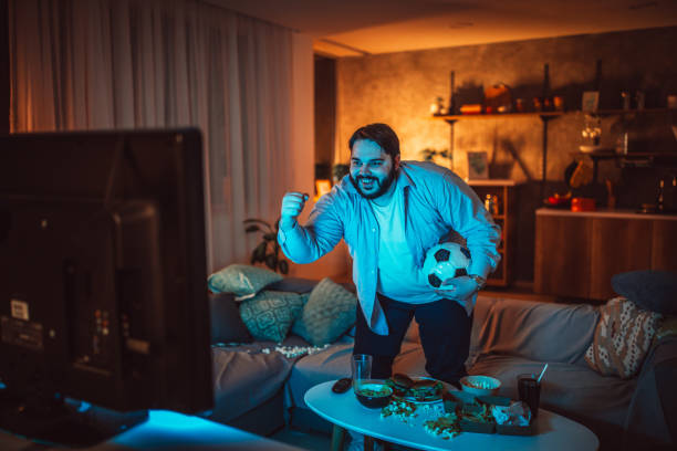 istock Overweight man watching a soccer match 1135953584