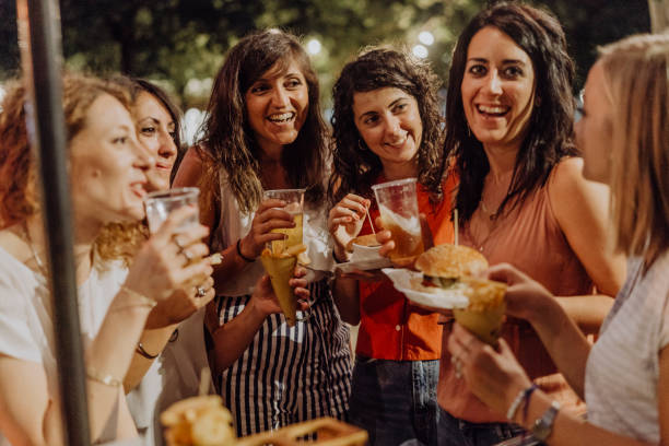 istock Happy friends having fun together, eating hamburger and drinking beer 1135953667
