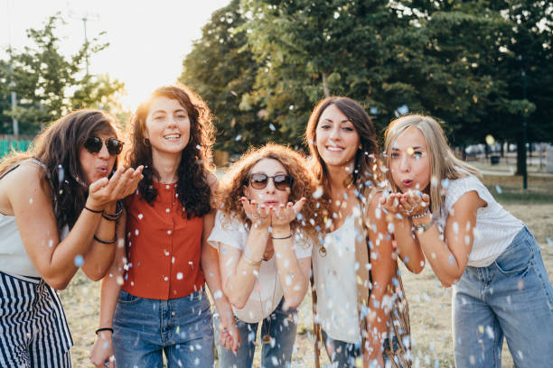 istock Friends having fun together with confetti at a party 1135953684