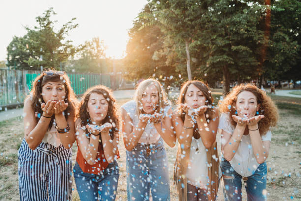 istock Friends having fun together with confetti at a party 1135953699