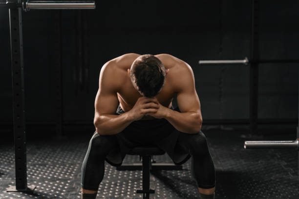 istock Strong sporty man sitting on gym bench suffering breakdown to overcome 1135955010