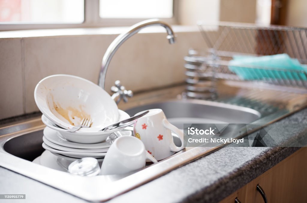 Dirty dishes in the sink Shot of kitchen sink full of dirty dishes Washing Dishes Stock Photo