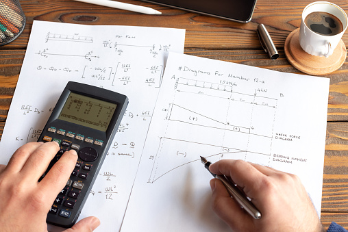 Civil Engineer or University Student Making Calculations Using Scientific Calculator