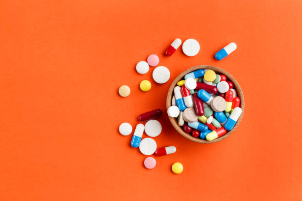 pillole multicolori sparse su uno sfondo luminoso, un luogo per il testo. - blue medicine narcotic healthy lifestyle foto e immagini stock