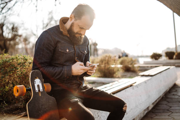 istock Skater man texting outdoors 1135956442