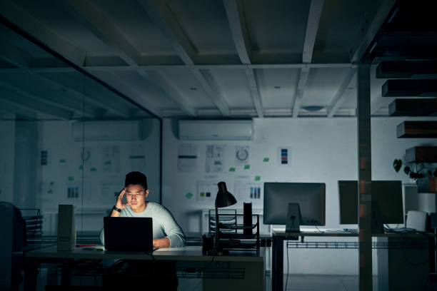 When stress starts to creep in Shot of a young businessman looking stressed during a late night in a modern office uncertainty photos stock pictures, royalty-free photos & images