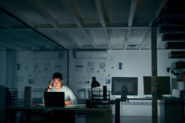 When stress starts to creep in Shot of a young businessman looking stressed during a late night in a modern office overworked stock pictures, royalty-free photos & images