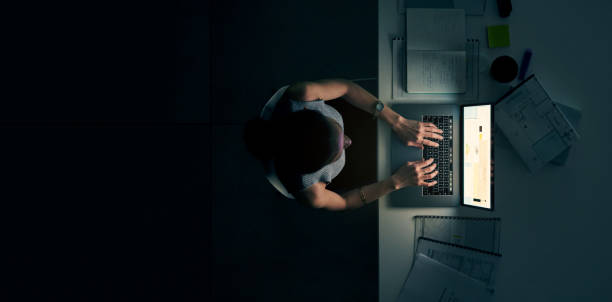 She puts the pro in productivity High angle shot of a young businesswoman using a laptop during a late night in a modern office deadline photos stock pictures, royalty-free photos & images