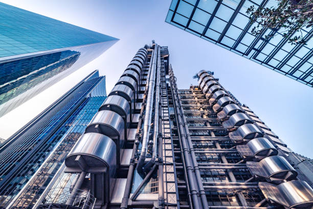 Abstract modern business buildings in financial district of London, England - stock image Extremely detailed abstract wide angle view up towards the sky in the financial district buildings of London City and its ultra modern contemporary architecture on a clear sky day. Shot on Canon EOS R full frame system with 14mm prime lens. Toned edit in blue to achieve more corporate look, image is ideal for background with plenty of copy space. lloyds of london photos stock pictures, royalty-free photos & images