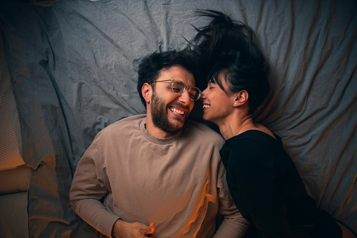 Young couple is spending time together on their bed.