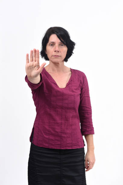 istock woman with stop sign on white background 1135958893