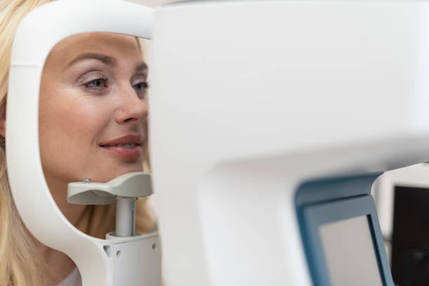 istock Beautiful blond woman looking through automatic refractometer 1135960479