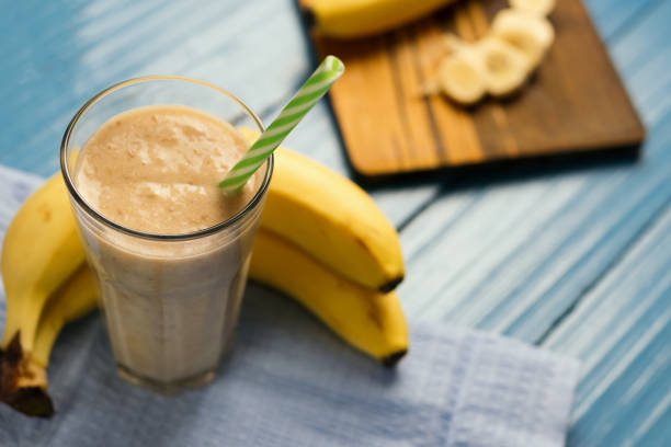 istock Milk smoothie with banana on wooden blue table 1135960641