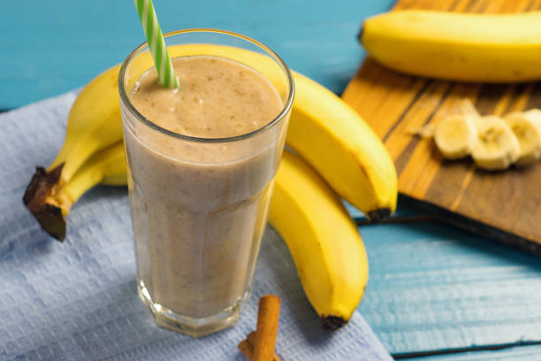 istock Milk smoothie with banana on wooden blue table 1135960646