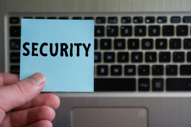 istock word SECURITY on sticky note hold in hand on laptop keyboard background. 1135962139
