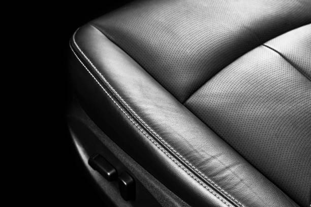 istock Black leather interior of a car. Perforated Leather comfortable seats with stitching isolated on black background. Car interior details. Car detailing. Car inside 1135962326