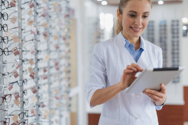 istock Waist up of a nice optician using her tablet for work 1135962931