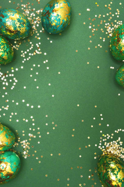 istock Easter eggs, dark green with gold on a green background. View from above. Flat lay. 1135963326