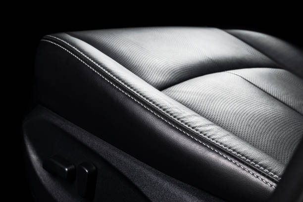 istock Black leather interior of a car. Perforated Leather comfortable seats with stitching isolated on black background. Car interior details. Car detailing. Car inside 1135963478