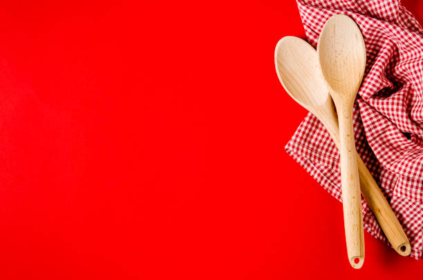 istock Kitchen textiles and wooden spoons on bright red background 1135963779