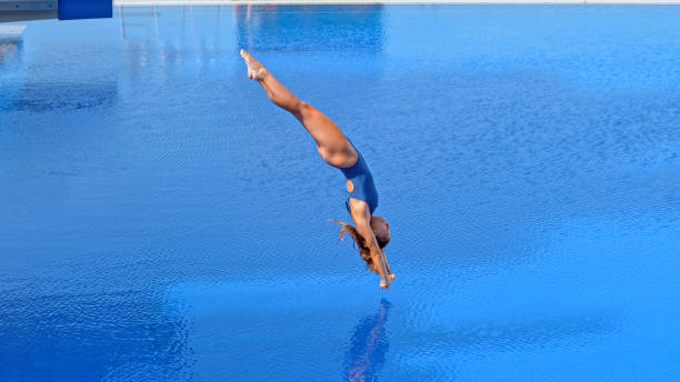 Young woman diving into swimming pool