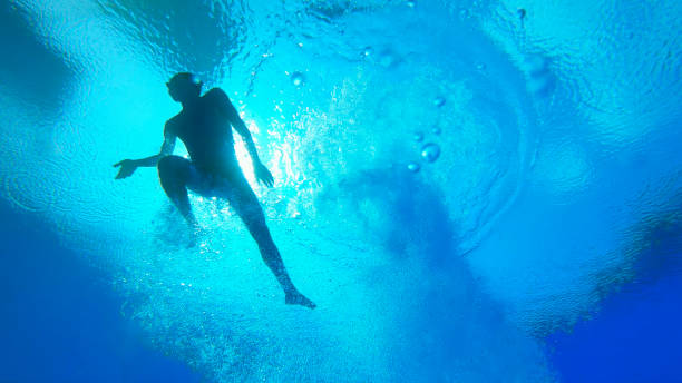istock Young man diving into swimming pool 1135964336