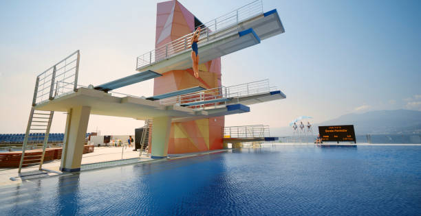 istock Female diver diving into swimming pool 1135964371