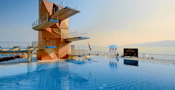 istock Female diver diving into swimming pool 1135964388